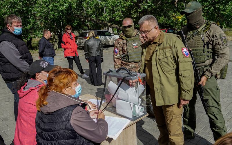 Mayor of Mariupol Konstantin Ivashchenko stands near armed servicemen as he speaks with members of the local election commission during voting in a referendum on the joining of Russian-controlled regions of Ukraine to Russia. Photograph: EPA