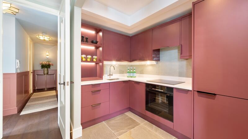 A kitchen wall was removed and the units are painted in Adventurer by Little Greene. Photograph: Matteo Tuniz MediaPro