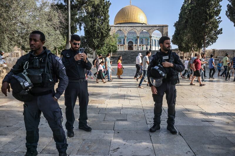 Israeli security forces protect a group of Jewish settler visitors as they walk past the Dome of the Rock mosque at the Al-Aqsa compound in Jerusalem on Sunday. Photograph: Ahmad Gharabli/AFP/Getty 