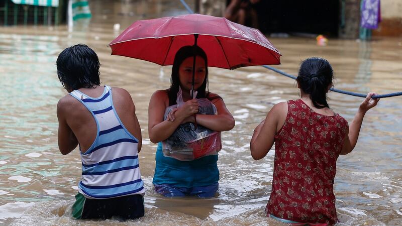 Residents walk in floodwaters in San Mateo town in  Rizal Province in the Philippines on Saturday. Photograph: Rolex De La Pena/EPA.