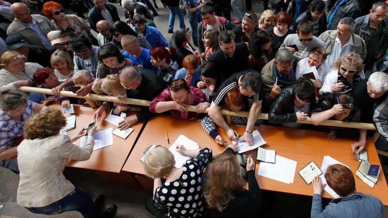 People stand in a line to receive ballots from members of a local election commission during the referendum on the status of Donetsk region in the eastern Ukrainian city of Mariupol today. Photograph: Reuters