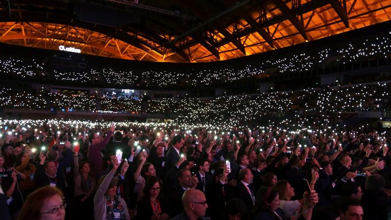Attendees turn on the light on their phones and raise them after being prompted to do so by Paddy Cosgrave, co-founder of the Web Summit. Photograph: Armando Franca/AP