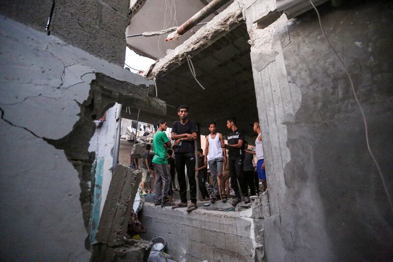 People search through buildings destroyed during Israeli air strikes in the Gaza Strip. Photograph: by Ahmad Hasaballah/Getty
