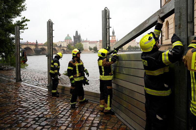 Firefighters adjust parts of the anti-flood barriers in Prague. Photograph: Petr David Josek/AP