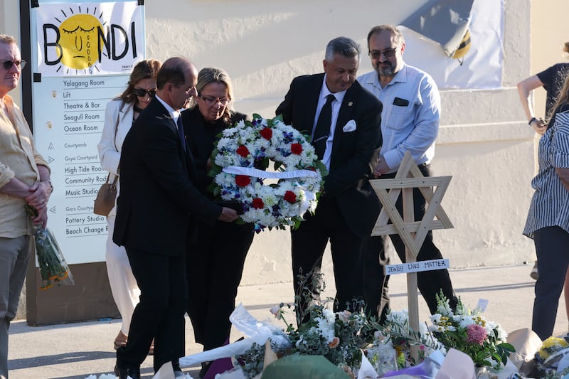Officials from the Australian-Turkish community lay a wreath as mourners gather in front of tributes in memory of victims of a shooting at Bondi Beach. Photograph: David Gray/AFP via Getty Images