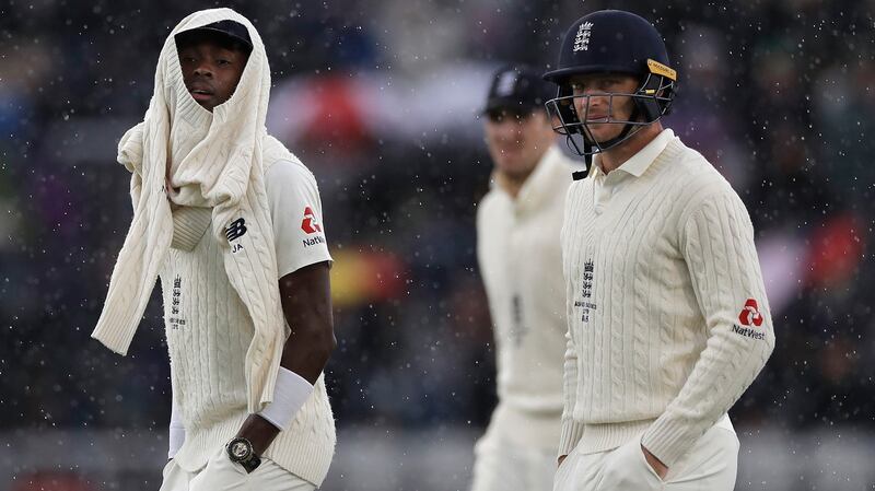 Jofra Archer and Jos Buttler of England leave the ground as rain stops play during day one of the fourth  Test against  Australia at Old Trafford. Photograph: Ryan Pierse/Getty Images