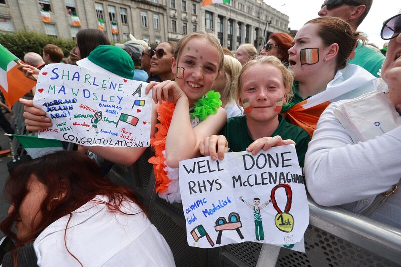 From left, sisters Neasa Moloney (12)  and Doireann (11) from Tipperary, display homemade posters during the homecoming event. Photograph: Liam McBurney/PA Wire