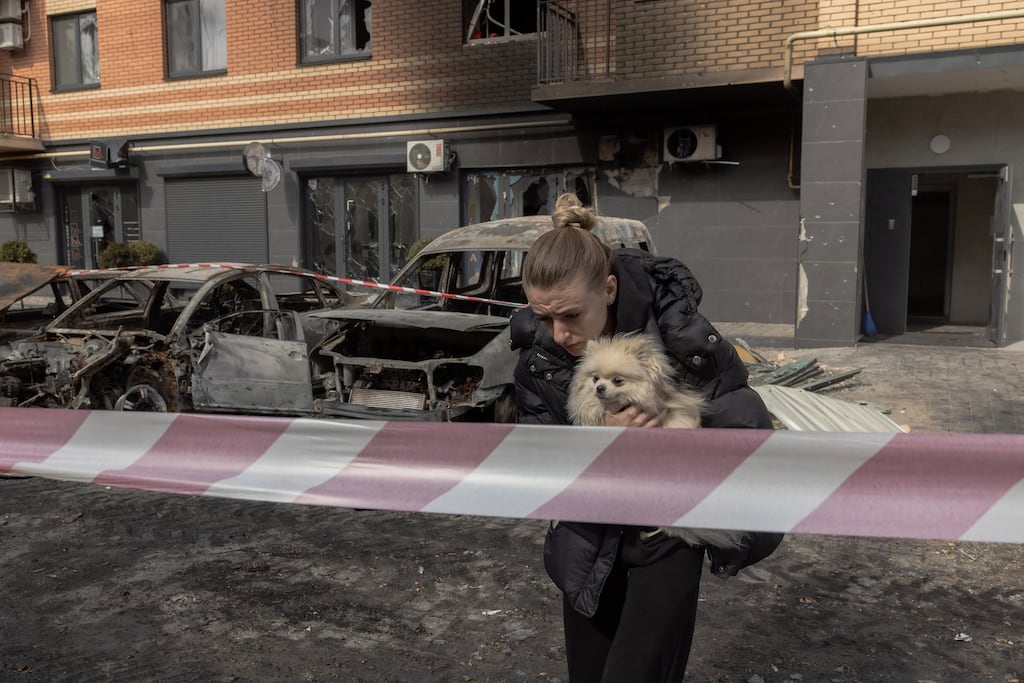 A woman carries a dog away from a damaged residential building following Russian drone and missile strikes in Kyiv on Thursday. Photograph: Roman Pilipey/AFP/Getty Images