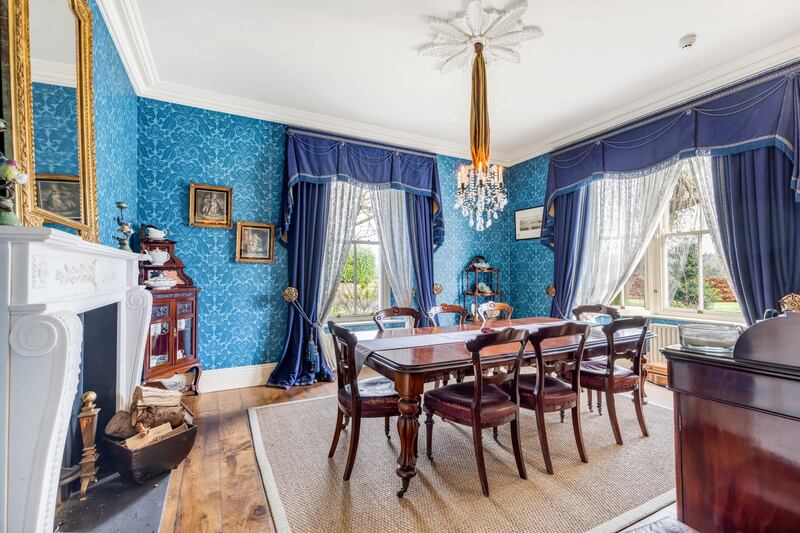 The diningroom has a candle chandelier and is blue to match the family collection of Royal Crown Derby chinaware