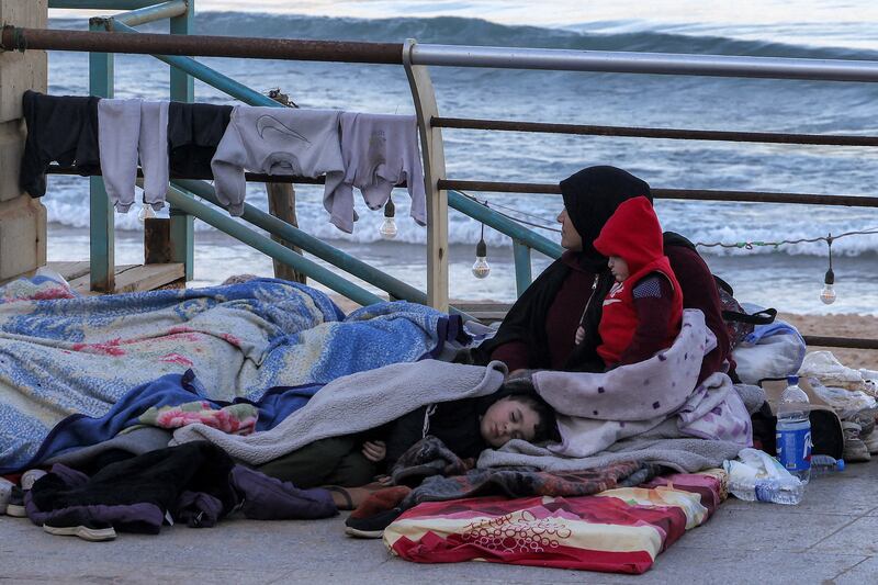 A woman sits with children wrapped in blankets in a makeshift encampment along the waterfront in Beirut on Tuesday. Photograph: Anwar Amro/Getty Images