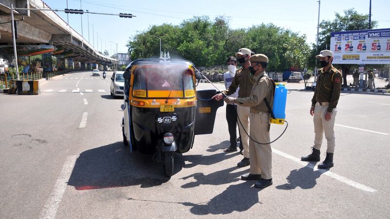 Police spray disinfectant on a three wheeler vehicle in Jammu, India. Photograph: Jaipal Singh/EPA