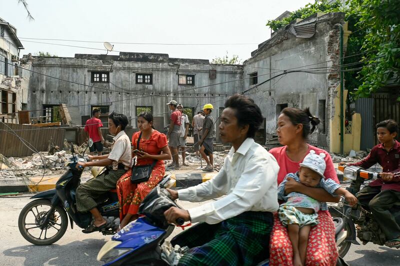 Motorbikes pass the rubble of a collapsed building in Kyaukse Township one week after the earthquake in Myanmar. Photograph: Sai Aung Main/AFP via Getty Images          