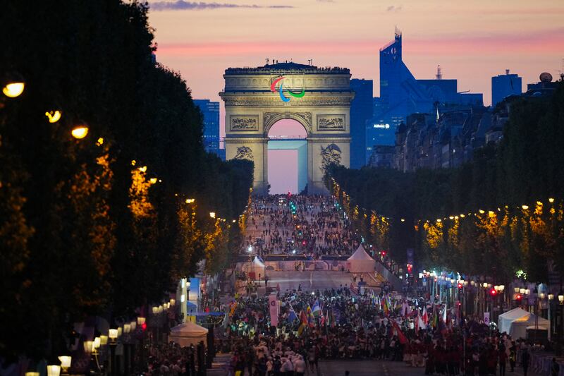 Athletes from different delegations parade on the Champs-Élysées  with the Arc de Triomphe in the background during the Paris 2024 Paralympic Games opening ceremony. Photograph: Dimitar Dilkoff/AFP/Getty 