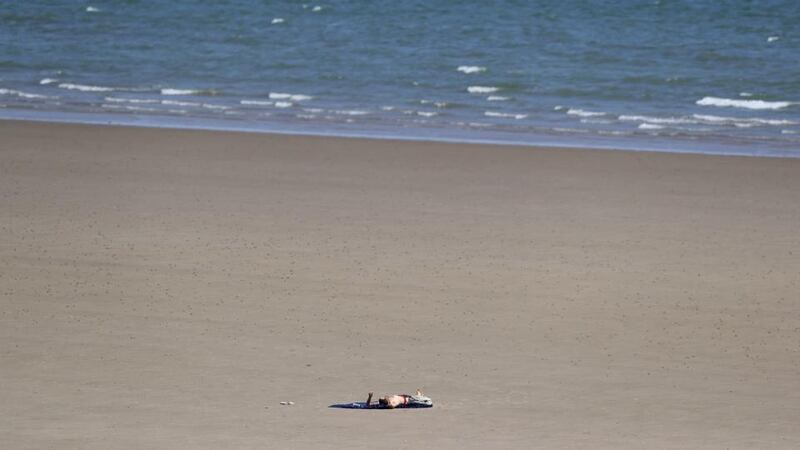 A man lies on Portmarnock beach, Co Dublin, as the warm weather continues. Photograph: Brian Lawless/PA Wire