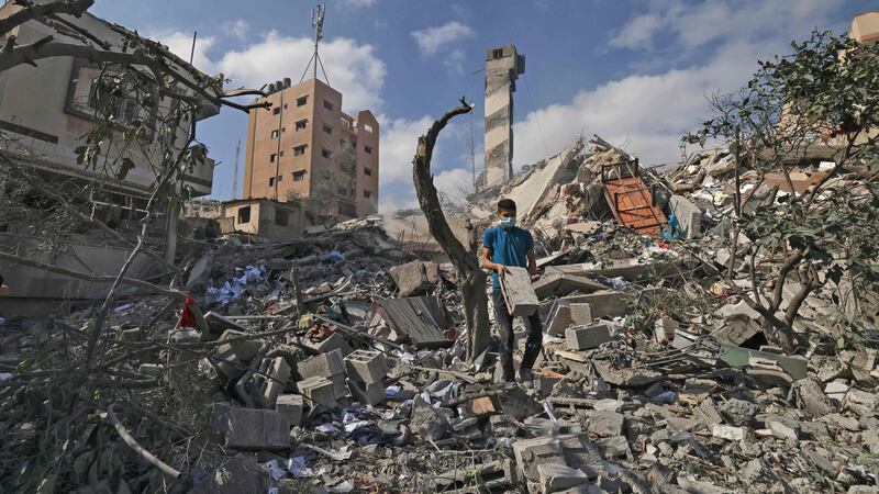 A Palestinian youth looks for salvageable items amid the rubbe of the Kuhail building which was destroyed in an early morning Israeli air strike on Gaza CityPhotograph: Mahmud Hams/AFP via Getty Images