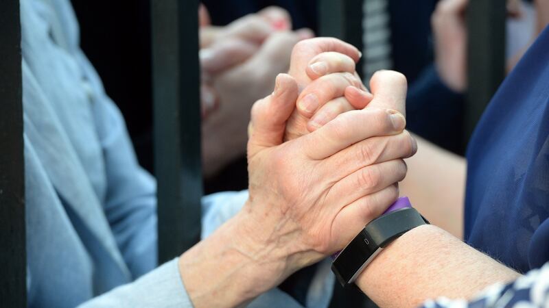 A member of the public offers support to a former Magdalene Laundry resident at the  ‘Dublin Welcomes Home the Magdalenes’ event at the Mansion House. Photograph: Cyril Byrne/The Irish Times.