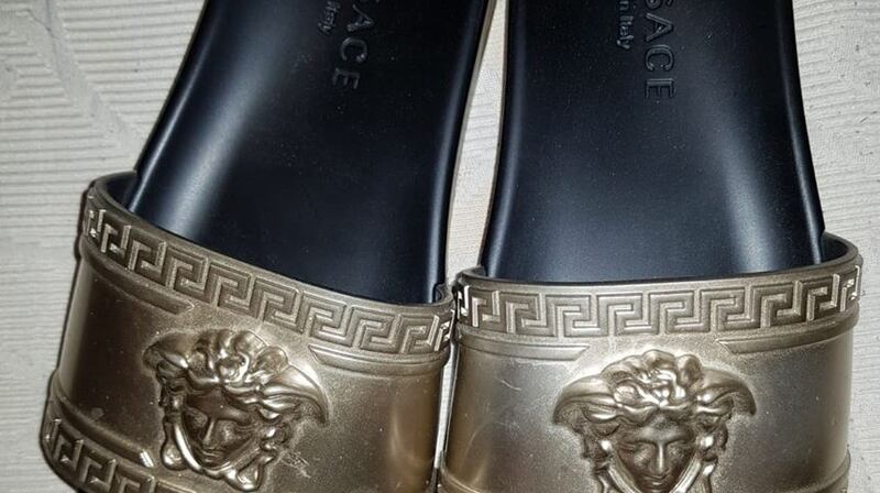 A selection of designer goods including a Gucci ‘manbag’ and a pair of  Versace flip flops were among the items seized during the operation. Image: CAB