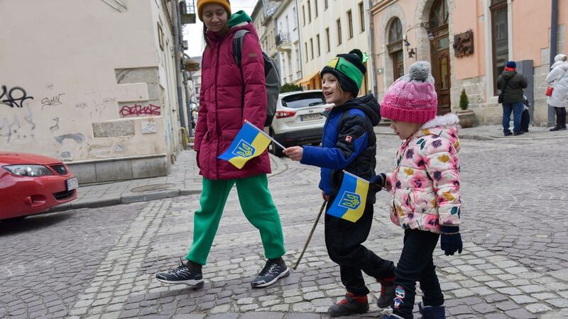A woman with children holding Ukrainian flags walk in the centre of Lviv on Saturday. Photograph: Vitaly Hrabar/EPA