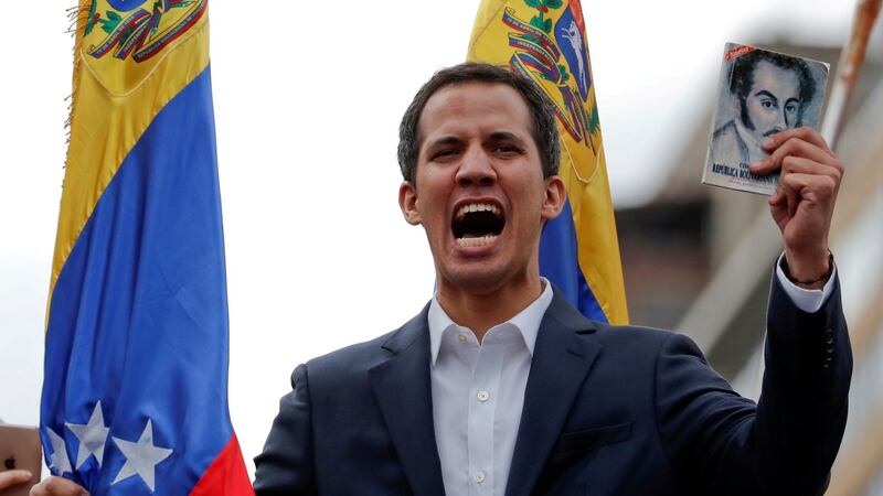 Juan Guaidó, leader of the Venezuelan opposition holds a copy of Venezuelan constitution during a rally against Nicolás Maduro’s government  in Caracas. Photograph: Carlos Garcia Rawlins/Reuters