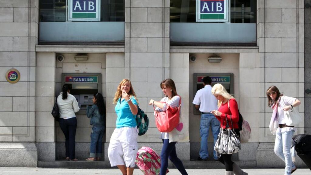 Pedestrians walk past a branch of Allied Irish Banks in Dublin