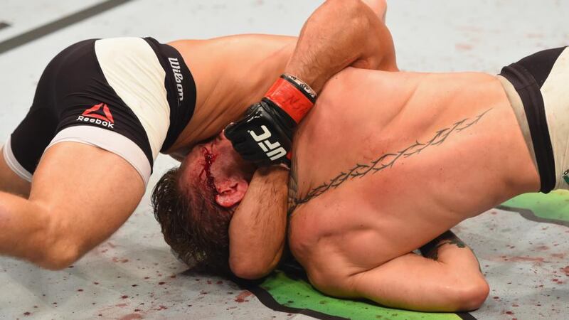 Conor McGregor struggles to escape from Chad Mendes during the second round. Photograph: Getty Images