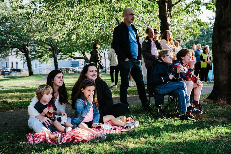 From the left Adam, Ciara and Emmie Bolger-Lawson and Sinead Murphy together with local residents of the Tenters, Dublin 8, watching the screening of new documentary promoting the housing scheme, in Oscar Square. Photograph Tiberio Ventura / The Irish Times