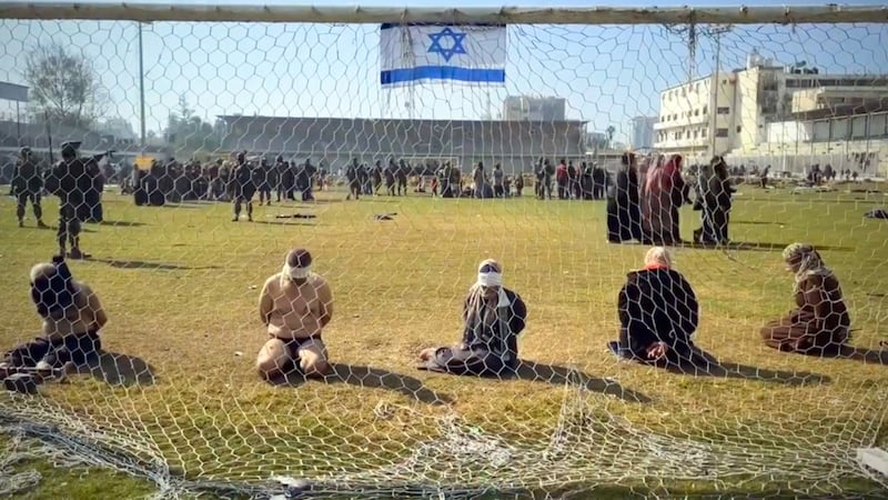 An edited video circulating on social media appears to show Palestinian women and men blindfolded with their hands tied behind their backs as they sit on the grass in front of a soccer goal in the stadium
