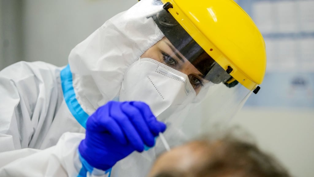 A nurse takes a sample from a man’s throat to test for coronavirus. Photograph:   Peter Komka/Pool/AFP via Getty Images