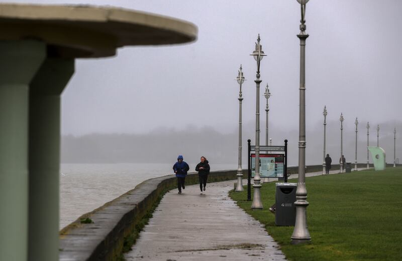 Joggers on the sea front in Clontarf in the wake of yesterday's flooding due to high tides and constant rain. Photograph: Colin Keegan/Collins.