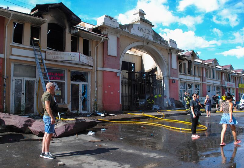 People walk past damages from a drone strike at Pryvoz Market in Odesa, Ukraine. Photograph: Igor Tkachenko/EPA