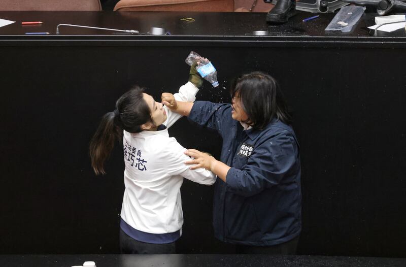 Taiwan opposition party Kuomintang (KMT) lawmaker Hsu Chiao-hsin (L) splashes water on Democratic Progressive Party (DPP) lawmaker Wang Mei-hui after the DPP occupied the night to avoid the passing of the third reading of amendments to the Civil Servants Election and Recall Act and other controversial bills at the Legislative Yuan in Taipei. Photograph: I-Hwa Cheng/AFP