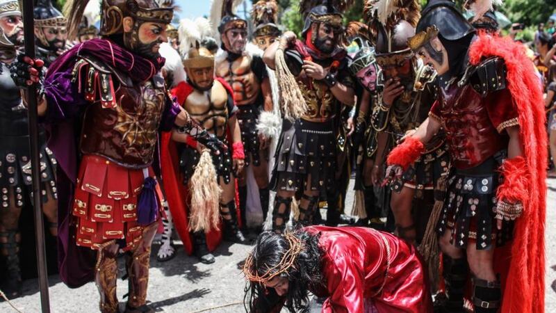 A Filipino portraying Jesus Christ carries a wooden cross next to ‘Morions’ (masked penitents) during the Good Friday re-enactment of the Passion of Christ in Boac, Marinduque island, Philippines. Photograph: Basilio H Sepe/EPA