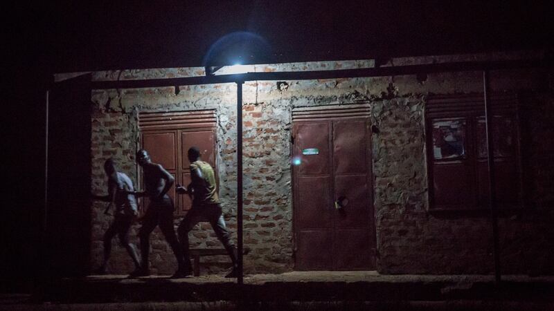 Men run away after they were spotted having an illegal gathering by soldiers on the outskirts of Gulu, northern Uganda. Photograph: Sally Hayden