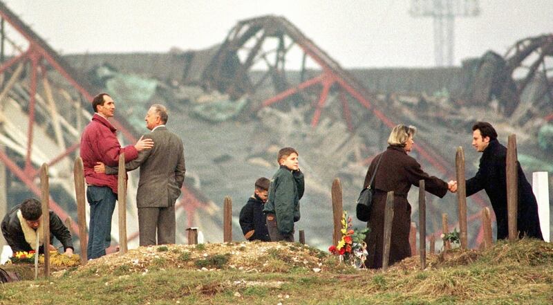 Bosnian Muslims greet each other at a cemetery overlooking the  Olympic stadium in Sarajevo in 1996. Photograph:  Danilo Krstanovic / Reuters