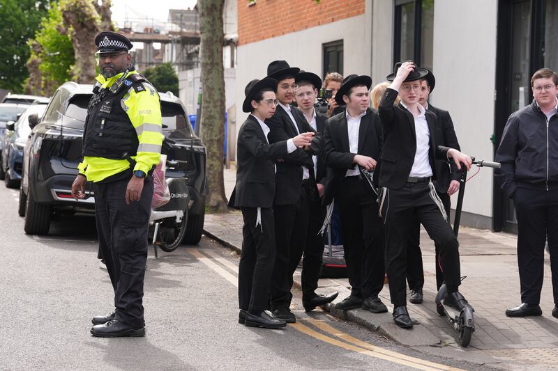 Members of the Jewish community at the scene in Golders Green, north-west London, after two men - one aged in his 70s and another in his 30s - were stabbed on Wednesday morning. The Metropolitan Police said a 45-year-old man was arrested and remains in custody.  Photograph: Lucy North/PA Wire