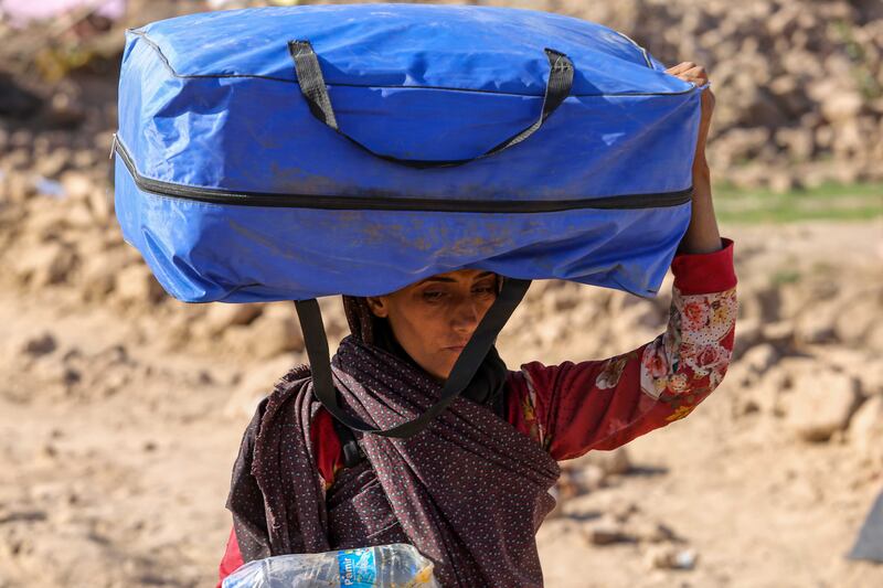 A woman carries a tent in the Zinda Jan district, the area worst hit by the earthquakes. Photograph: Samiullah Popal/EPA