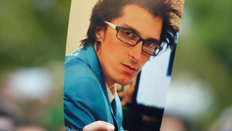 A  fan hold up a photo of the late  Iranian musician, composer and pop star Morteza Pashaei during his funeral outside the Vahdat Hall in Tehran today.  Photograph: Abedin/Taherkenareh/EPA.