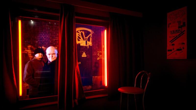 A video installation shows men taking a look inside a brothel at the Red Light Secrets museum in Amsterdam. Photograph: Koen van Weel/AFP/Getty Images)