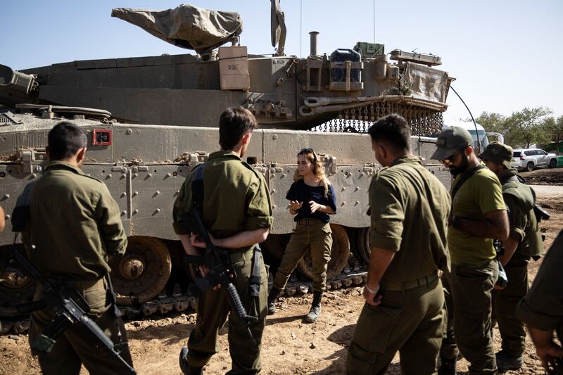 An Israeli army instructor talks to soldiers next to a Merkava battle tank at the border with the Gaza Strip in southern Israel on Thursday. Photograph: Christophe Petit Tesson/EPA