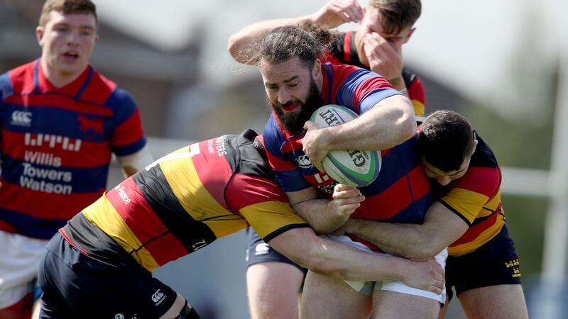 Clontarf’s Mick McGrath is tackled by  Tom Murphy and Aaron Connelly of Lansdowne during the All-Ireland League Division 1A semi-final at Castle Avenue. Photograph: Dan Sheridan/Inpho