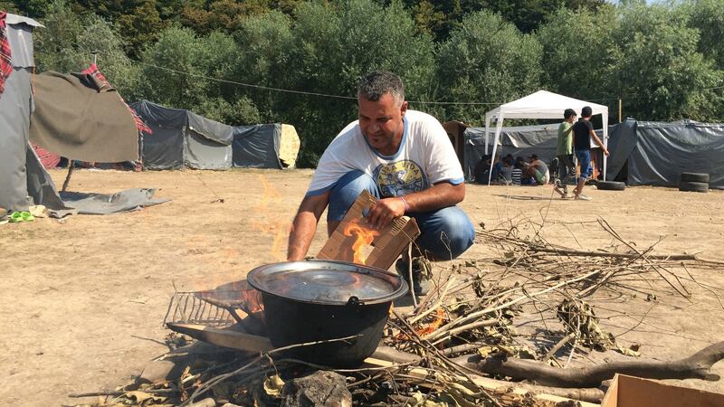 A man cooks at a camp in Velika Kladusa, near Bosnia’s border with Croatia,  now home to hundreds of migrants. Photograph: Daniel McLaughlin