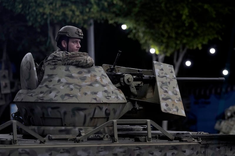 A Lebanese army soldier sits  on the top of an armoured personnel carrier at the site of an Israeli airstrike in Beirut’s southern suburbs. Photograph: Bilal Hussein/AP