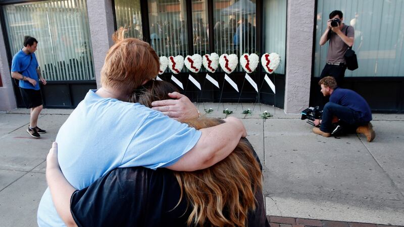 Two women hug each other in front of wreaths displayed for the nine victims of a shooting, in the Oregon District of Dayton, Ohio, August 4th 2019. Photograph: David Kohl/EPA