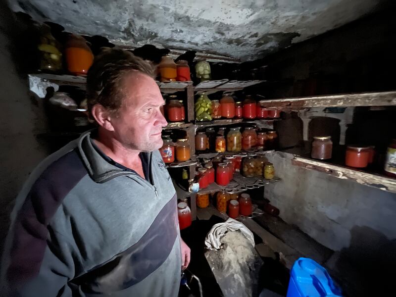 Andriy Pivovar in the cellar of his family's cottage in Mospanove, northeastern Ukraine, where his family store pickled vegetables and jams for winter, and he spent much of this year sheltering from shells and missiles fired over this village when it was on the frontline of the Russia-Ukraine war.  Photograph: Daniel McLaughlin