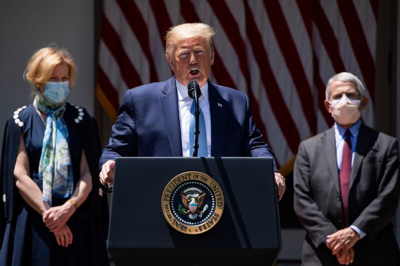 Flanked by Dr Debbie Birx (left) and Dr Anthony Fauci, both wearing masks,  Trump discusses coronavirus vaccination projects at the White House on May 15th. Photograph: Samuel Corum/The New York Times