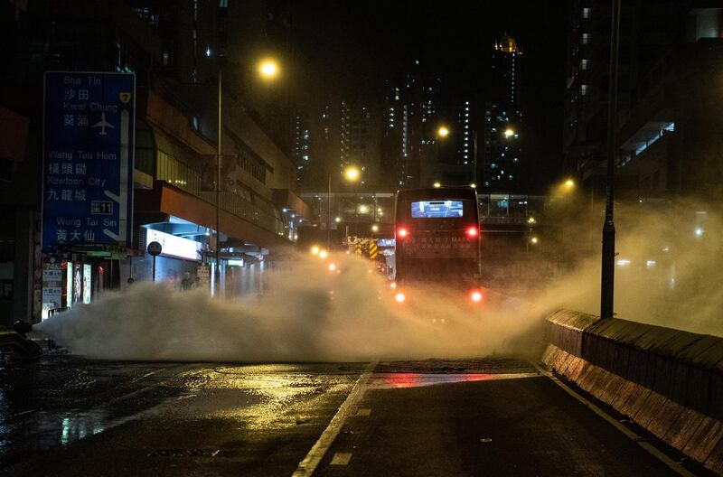 A  bus drives through the jet of a broken fire hydrant during a protest against a government ban on face masks in Wong Tai Sin,  Hong Kong on Friday. Photograph: Getty images