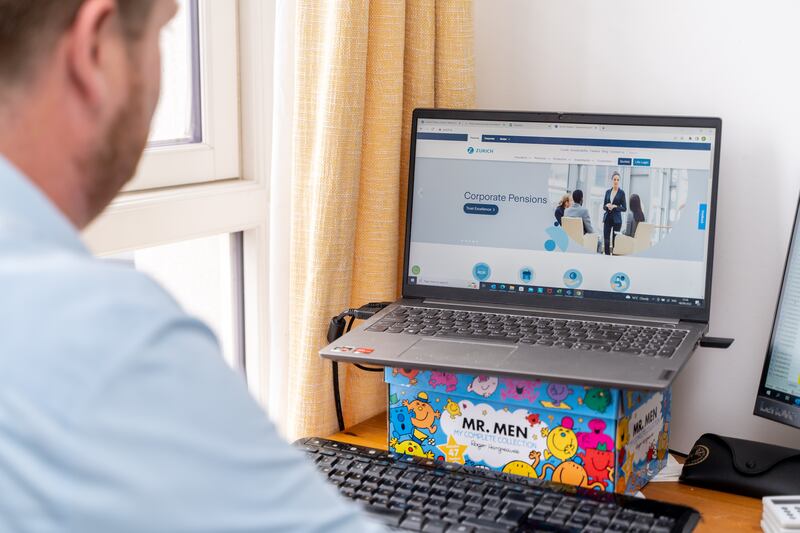 Wherity at his desk in his home office, where he has improvised laptop levels using a Mr Men box to raise it from the tabletop