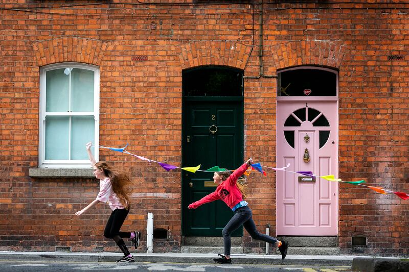 Nicole Kirwan, aged 11, and Carys O'Leary, aged 10, at Meath Place, Dublin 8. Children love preparing for parties so ask them to drop off invites to neighbours, make posters or help put up bunting the day before. Photograph: Shane O'Neill/Coalesce