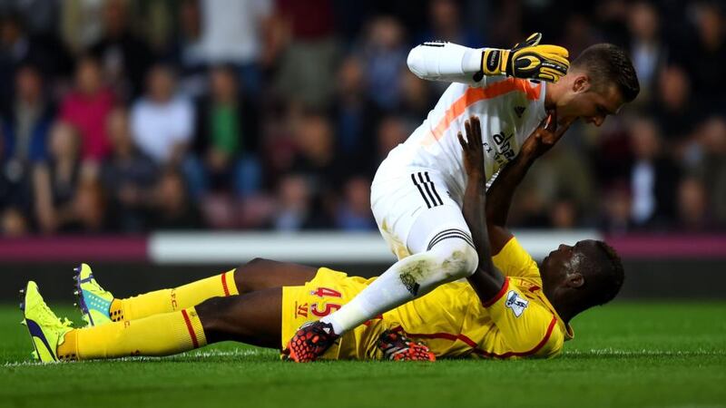 Mario Balotelli of Liverpool and Adrian of West Ham clash during the Barclays Premier League match   at Boleyn Ground. Photograph:  Mike Hewitt/Getty Images