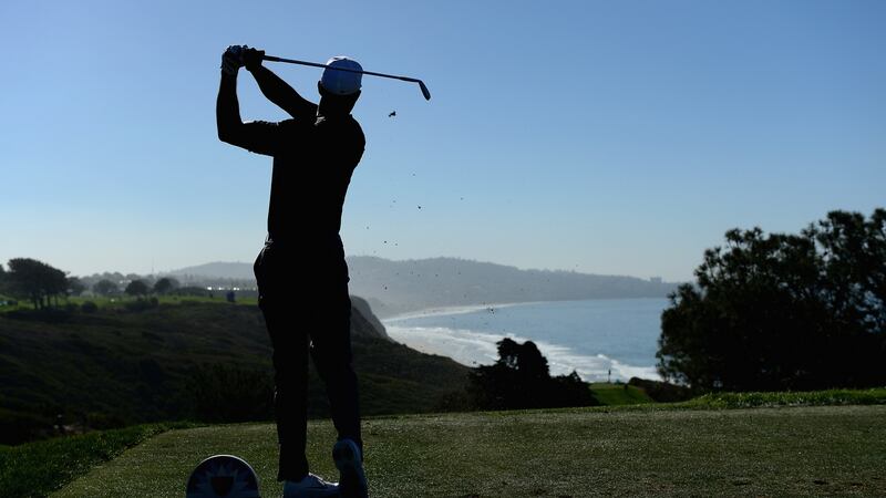 Woods tees off at the 15th. Photo: Donald Mirale/Getty Images
